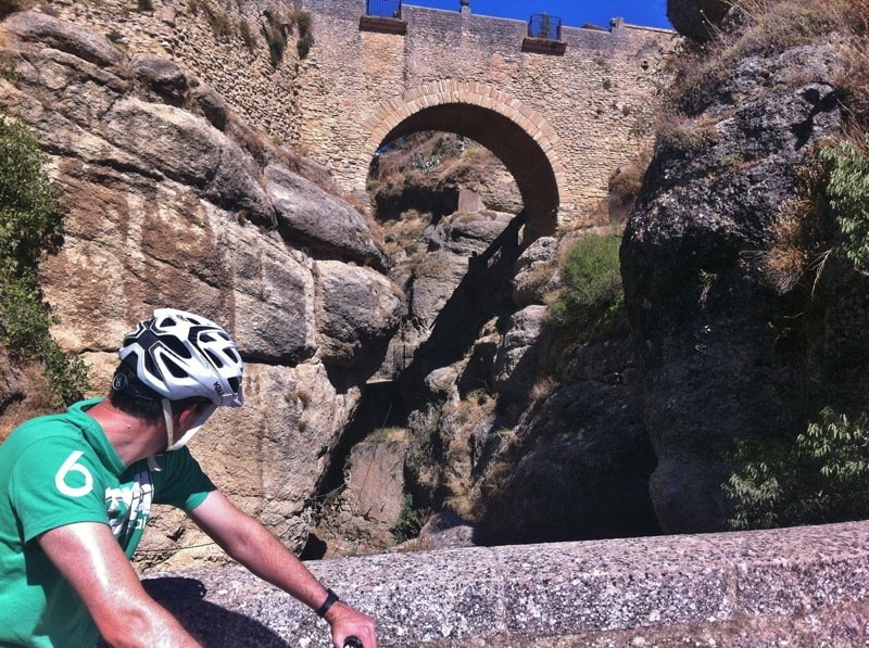City tour riders looking at the Old Bridge in Ronda gorge